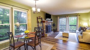 Sala de estar com lareira, área de jantar e sofá.
