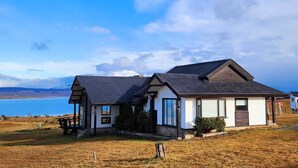 Una casa moderna con un'ampia finestra, un portico e vista sull'oceano.