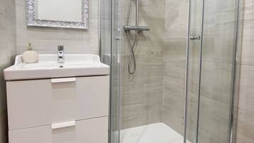 Habitación Confort | Baño | Cabezal de ducha tipo lluvia, secador de pelo, zapatillas y bidé