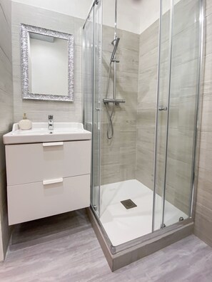 Comfort kamer | Badkamer | Een regendouche, een haardroger, pantoffels, een bidet