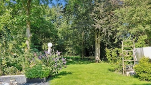 Ein gepflegter Garten mit vielfältigen Pflanzen und einer Holzkonstruktion.