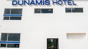Un bâtiment dont la façade porte l’enseigne « DUNAMIS HOTEL ».