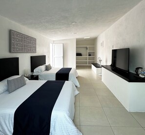 A hotel room with two beds, a TV, a desk, and a walk-in closet. - DUNAMIS HOTEL (Jilotepec)