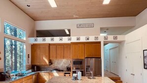 Eine moderne Küche mit Holzausstattung, einer Granitabdeckung und einem Edelstahlkühlschrank.