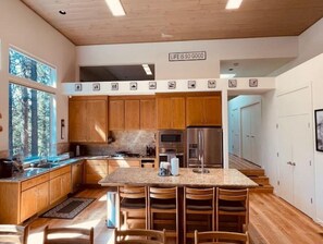 A modern kitchen with wooden cabinets, a granite countertop, and a stainless steel refrigerator. - Modern 4BR  Playground  Deck (Shaver Lake)