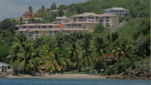 A beachfront hotel with multiple buildings, palm trees, and a sandy beach. - T3 vue mer sur les Caraïbes (Les Trois-Îlets)
