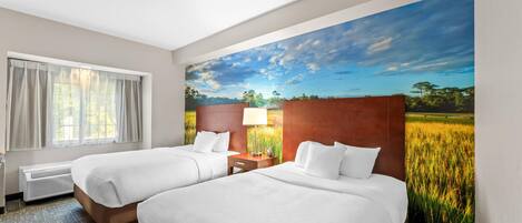 Habitación de hotel con dos camas, una ventana con cortinas, una lámpara fijada a la pared y un cuadro grande de un campo.