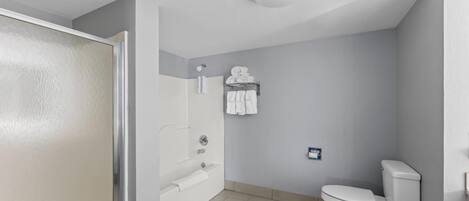 Casa de banho com sanita, lavatório e porta-toalhas.