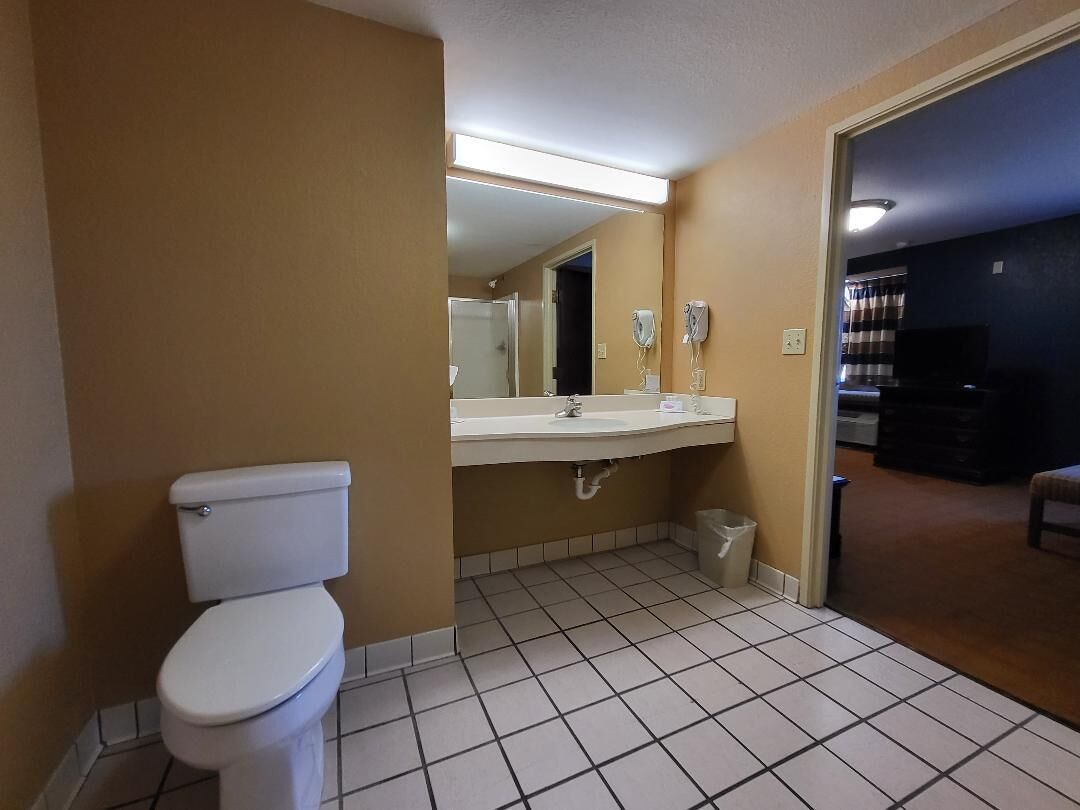Un baño con inodoro, lavamanos y espejo.