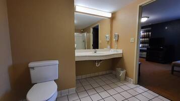Un baño con inodoro, lavamanos y espejo.