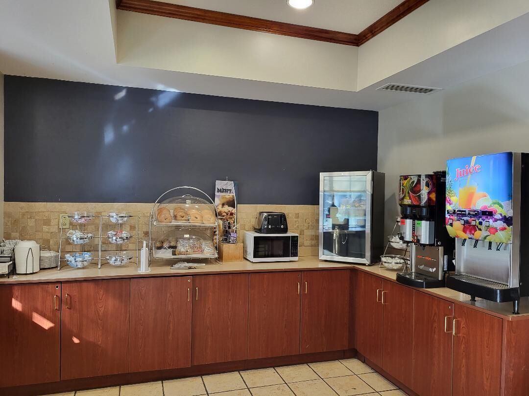 Una kitchenette equipada con microondas, tostadora y cafetera. Incluye también un refrigerador y dispensador de jugo.