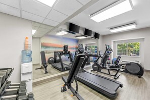 A gym with treadmills, elliptical machines, and a water dispenser. - Clarion Pointe Starkville near University (Starkville)