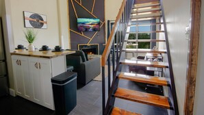 A modern kitchen with white cabinets, a wooden countertop, and a black trash bin. - SC 2508: Spoil yourself in this remodeled & classy 2BR loft w/pool! (Snowshoe)