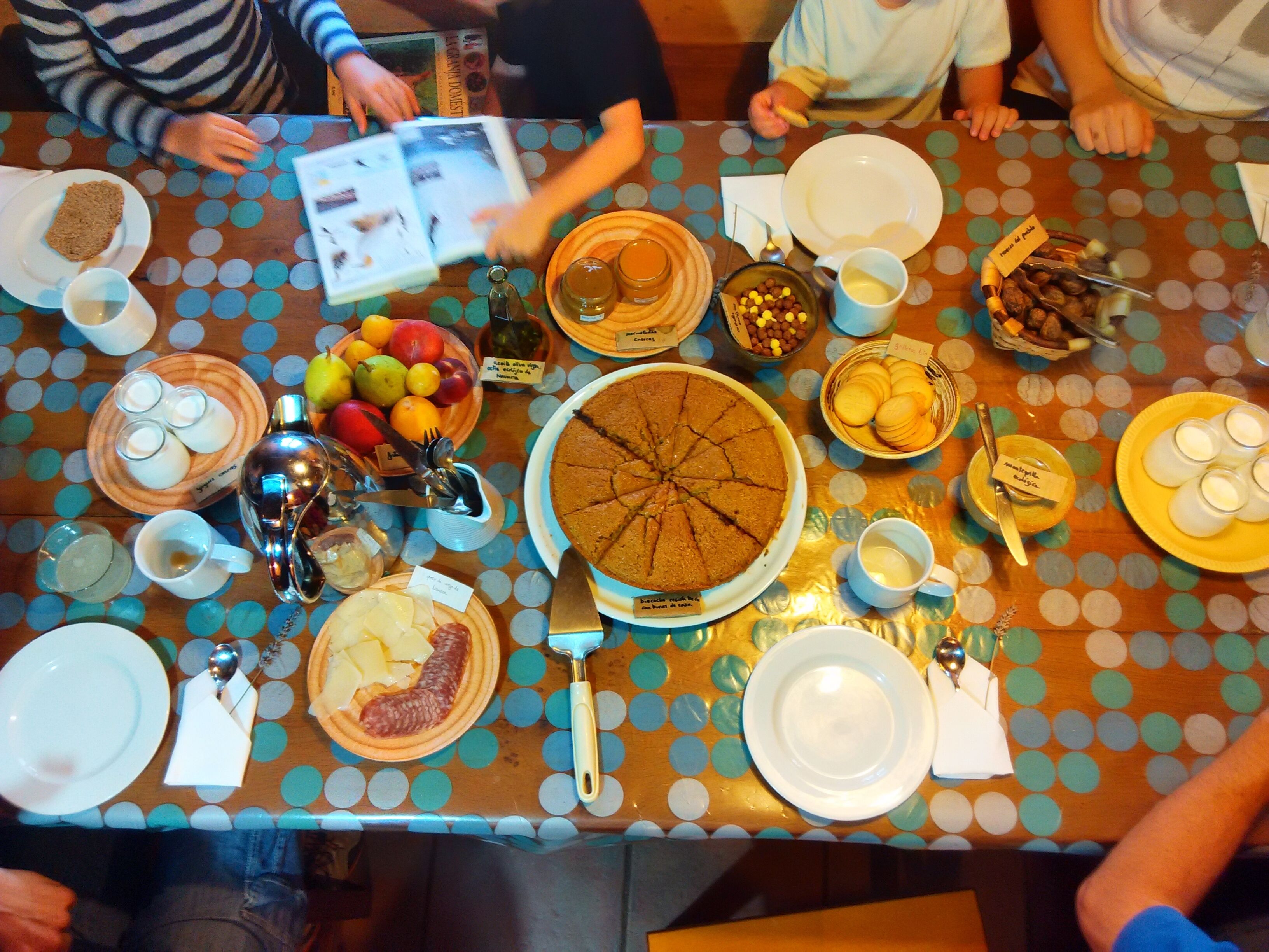 A dining table with various dishes, utensils, and a book.