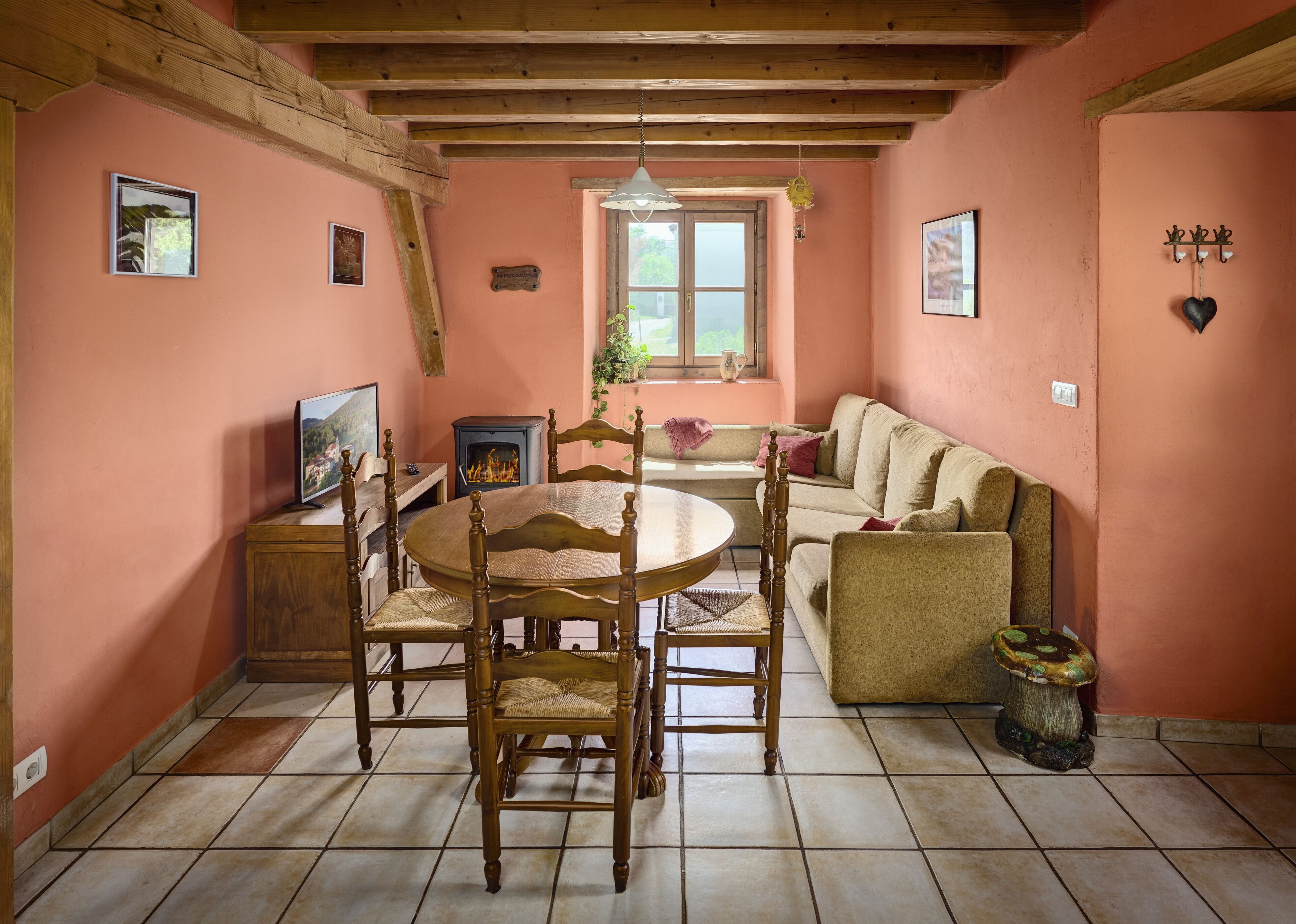 Una habitación acogedora con una mesa de madera, sillas, un sofá y una chimenea.