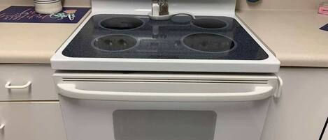A white stove with four burners and a digital control panel.