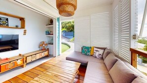 Un salon moderne avec un canapé, une table basse en bois et un téléviseur.