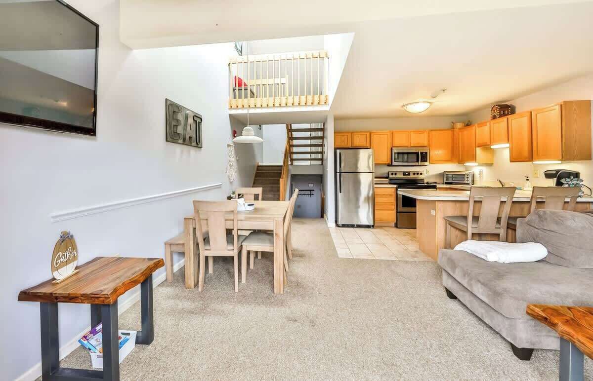 Un espace de vie compact comprenant un coin repas, une kitchenette et une chambre en mezzanine.