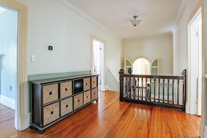 A hallway with wooden flooring, a built-in storage unit, a staircase with a railing, and a light fixture on the ceiling. - Clonmel Acres: Hot Tub + Mins to Hazy Mtn & BMB (Afton)