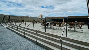 A rooftop terrace with outdoor seating and a staircase leading up. - Condomínio Piazza diRoma Acqua Park Splash (Caldas Novas)