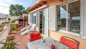 A patio with a table, chairs, and a grill area. - Ruhiges und Sonniges Haus in Paguera (Peguera)