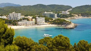 A coastal town with buildings near the beach, boats in the water, and green hills in the background. - Ruhiges und Sonniges Haus in Paguera (Peguera)