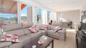 A modern living room with a sectional sofa, a coffee table, and a TV. - Ruhiges und Sonniges Haus in Paguera (Peguera)