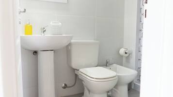 Een moderne badkamer met toilet, hygiëneslot en wastafel.
