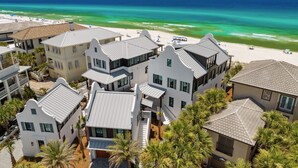 A coastal residential area with multiple houses, a beach, and a clear view of the ocean.