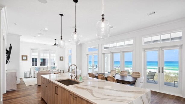 A spacious kitchen with a large island, wooden cabinets, and pendant lighting.