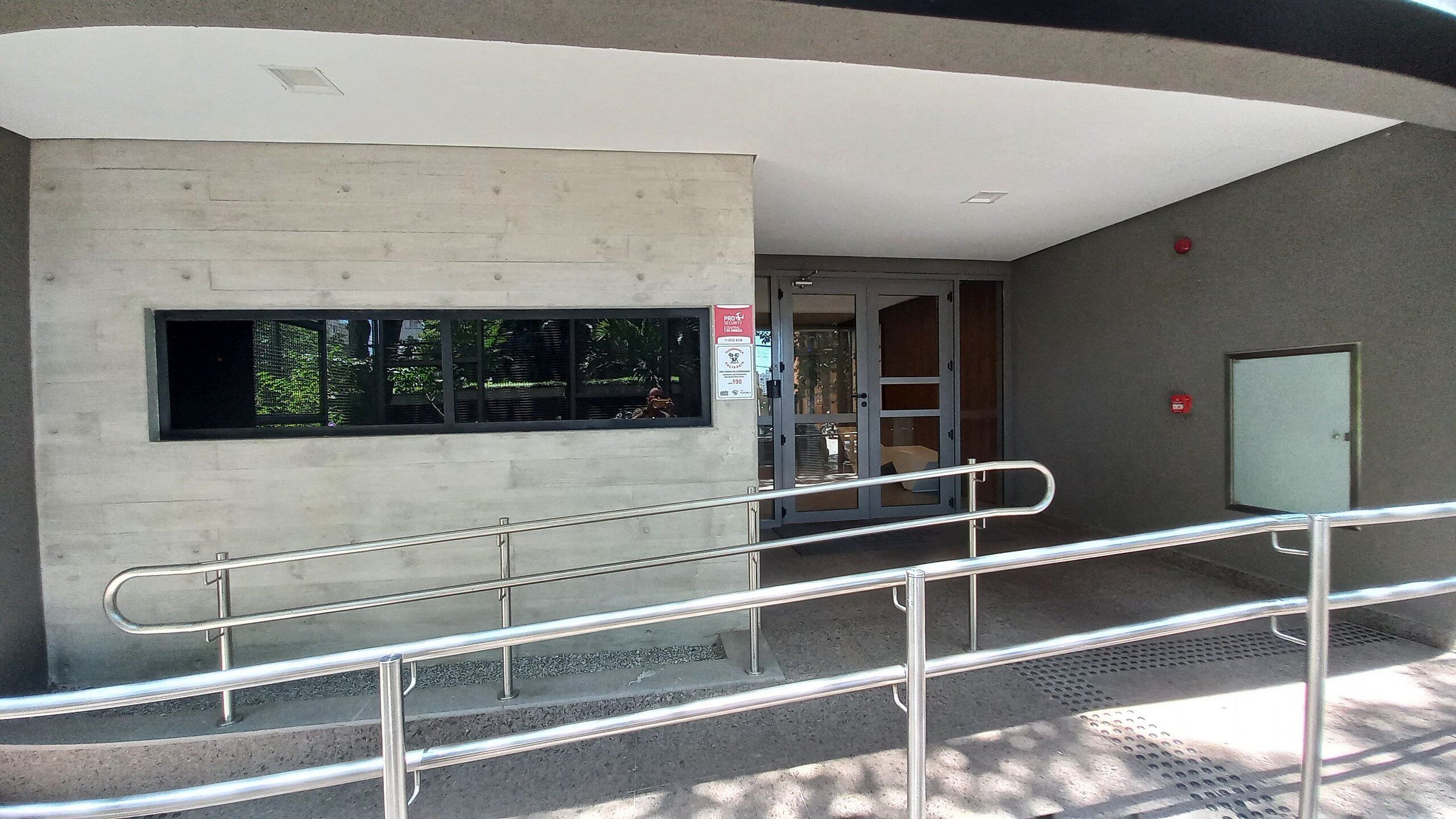 A building entrance with a concrete wall, a metal staircase, and a door.