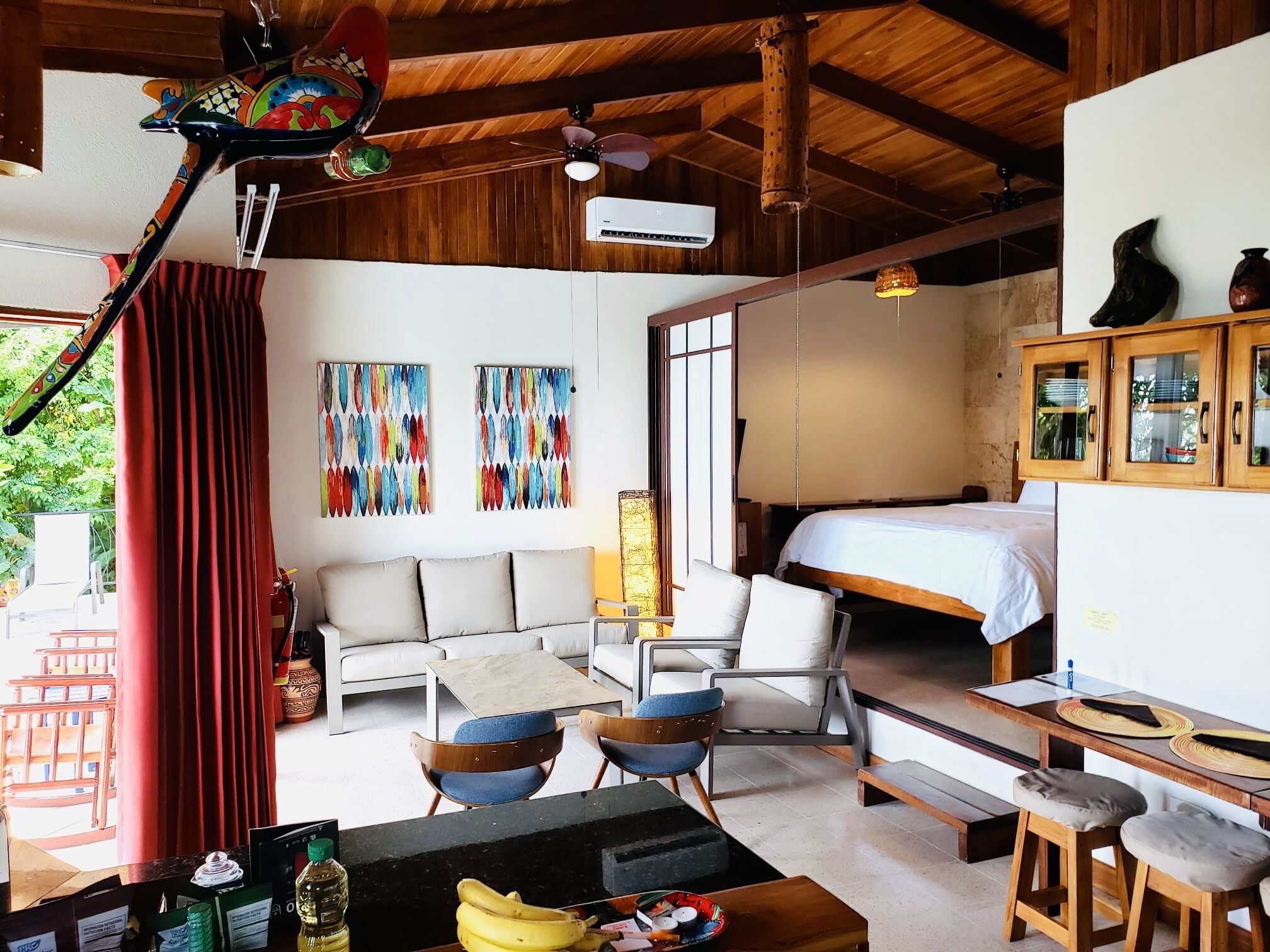 Une pièce comprenant un lit, un canapé, une table à manger et un ventilateur de plafond.