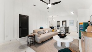 Un salon moderne avec un canapé, une table basse et un ventilateur de plafond.