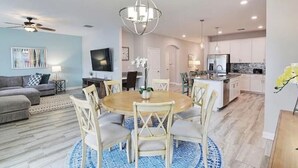 A modern living room with a round dining table, a sofa, and a TV. - Beautiful Home In Davenport, FL (Davenport)