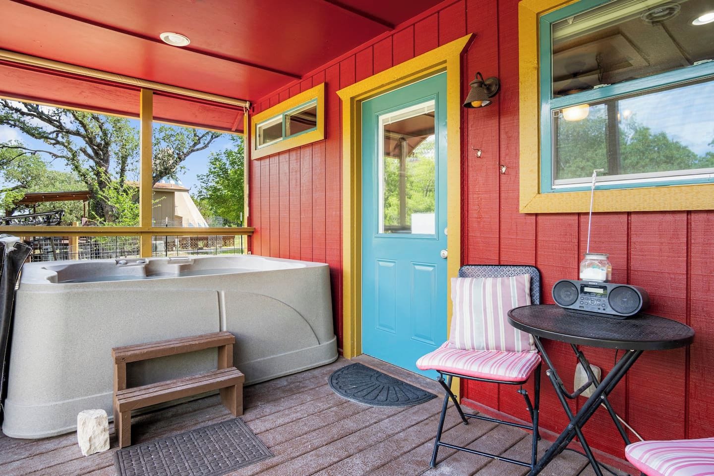 A hot tub, a door, a chair, and a table with a radio.