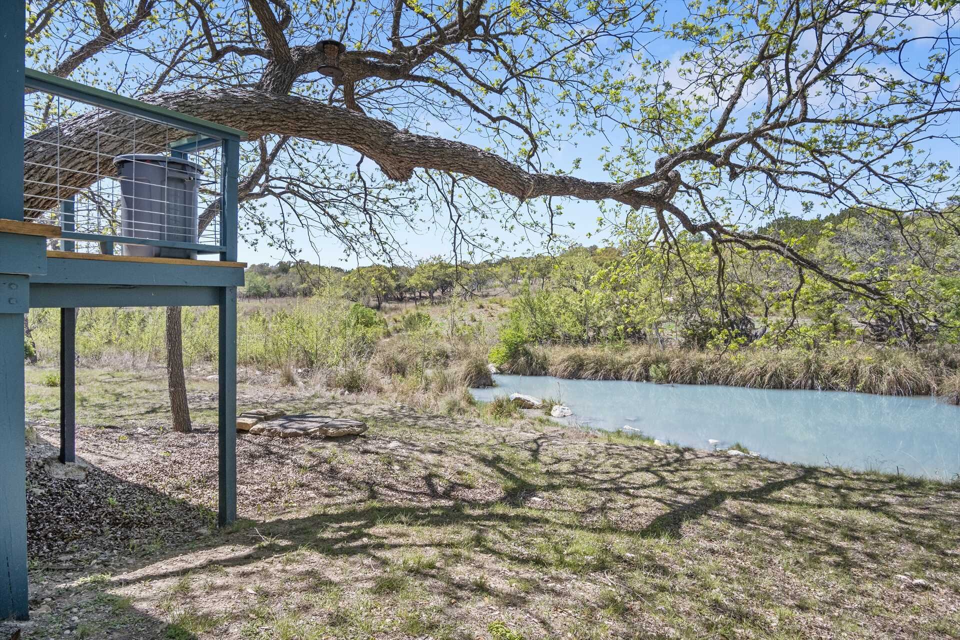 Un paysage naturel comprenant une rivière, des arbres et une structure métallique.