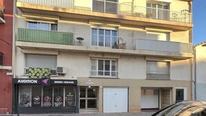 A multi-story building with a ground-floor shop named 'Audition' and 'Bribes-Herand'. - Spacieux Studio Pour Toute la Famille (Palavas-les-Flots)