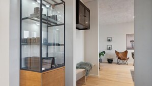 Un interno moderno con una vetrina, una panca in legno, una poltrona in pelle e un mobile a parete.