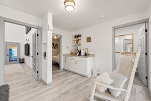 A modern interior with a kitchen, dining area, and a living room with a large chair. - Loveland Oasis w/ Indoor Heated Pool & Game Room (Loveland)