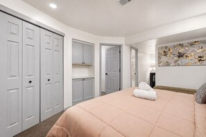 A bedroom with a large bed, a wardrobe, and a door leading to another room. - Loveland Oasis w/ Indoor Heated Pool & Game Room (Loveland)