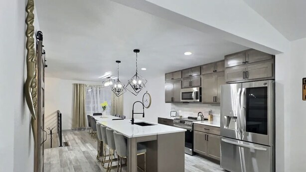 A modern kitchen with a central island, stainless steel appliances, and pendant lighting. - Loveland Oasis w/ Indoor Heated Pool & Game Room (Loveland)