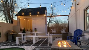 A patio with a fire pit, outdoor seating, and string lights. - Loveland Oasis w/ Indoor Heated Pool & Game Room (Loveland)