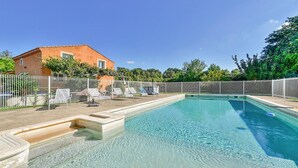 A swimming pool with lounge chairs and a fenced area, surrounded by greenery and a building. - Awesome home in Saint Martin de Crau (Saint Martin de Crau)