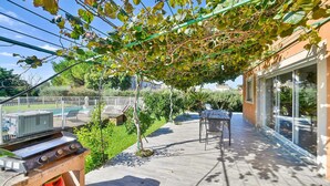 A patio with a grill, outdoor seating, and a view of a swimming pool and greenery. - Awesome home in Saint Martin de Crau (Saint Martin de Crau)