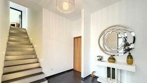 A modern interior with a staircase, a large mirror, and a minimalist decor. - Dream House 2, by LSA Madeira (Calheta)