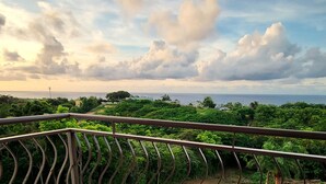 A balcony with a view of a lush landscape and the sea. - Ocean views, amazing sunset, pool and peaceful surroundings.  (Rincon)