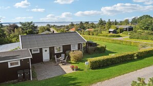 A house with a paved patio, a small garden, and a view of a lake.