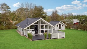 A modern house with a large glass front, a deck, and a small attached garage. - Amazing home in Tarm with WiFi (Tarm)