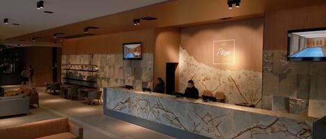 A modern reception area with a marble counter, seating, and a television screen displaying 'Plaza'.
