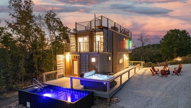 A modern multi-story building with a hot tub and outdoor seating area.
